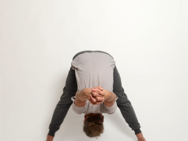 07 gegrätschte-stehende-Vorbeuge-Prasarita-Padottanasana-Yoga-im-Raum